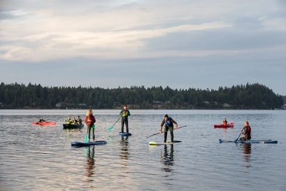 students enjoy paddleboarding and kayaking off of the Evergreen beach