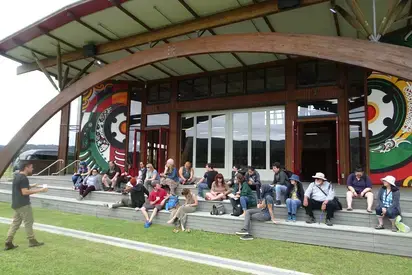 a class sitting on the steps on the native decolonization course abroad