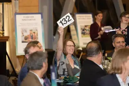 person raising sign at an auction