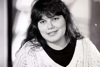 Portrait of Raquel Salinas with long dark hair and a white sweater