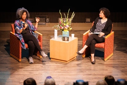 Dr. Alexis Pauline Gumbs speaking with Cholee Gladney on stage in the recital hall