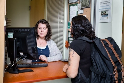 An Evergreen staff member helps a student with financial aid