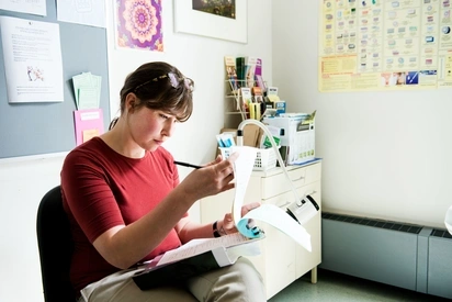 Health administrator reviews medical files while sitting in a doctor's office