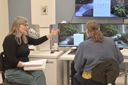 A lab technician at Evergreen instructing a student on how to use the new scanning electron microscope