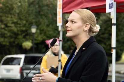 Jacie Hoag in profile speaking at a podium