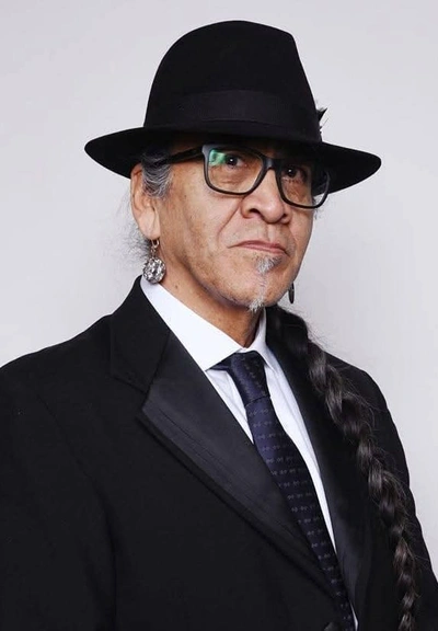 Portrait of Ed NoiseCat wearing a black hat