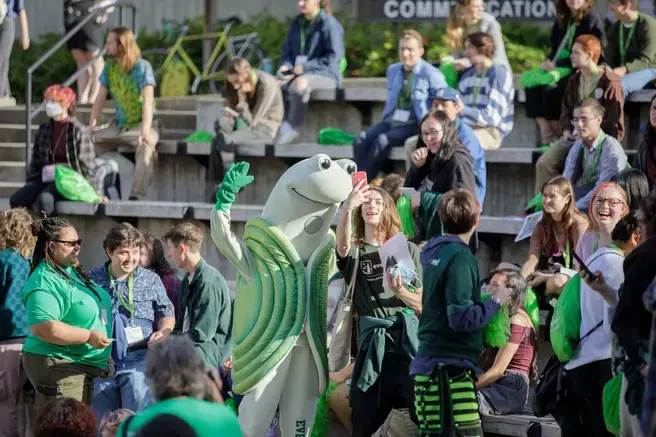 speedy the geoduck poses for a selfie with students at New student orientation