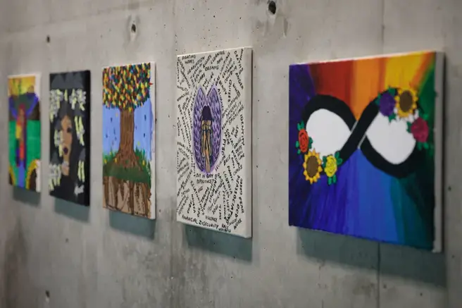 5 colorful paintings on a concrete wall
