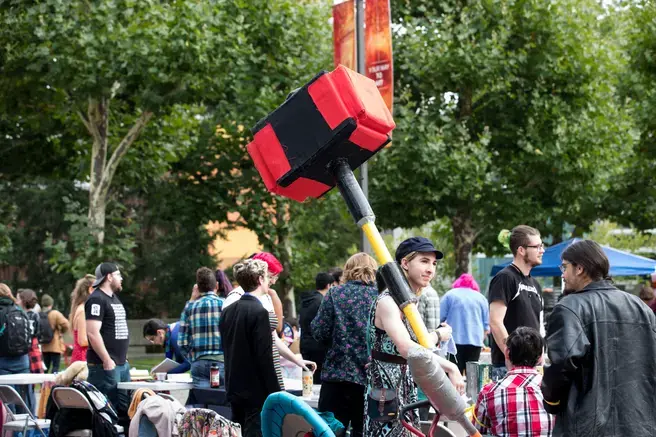 Student with a giant red foam hammer standing in a large group of students