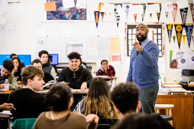 a teacher speaking to a classroom of high school students 