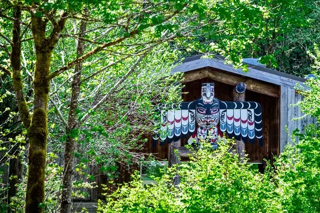 Image of tribal longhouse in lush forest at Evergreen Olympia campus