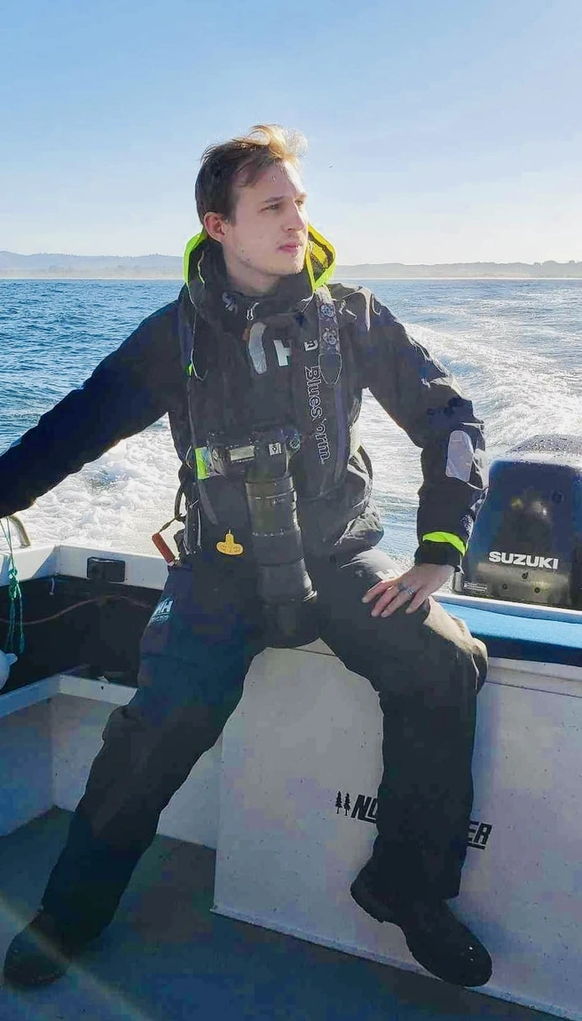 Kevin Lester sitting on the side of a boat out on the water