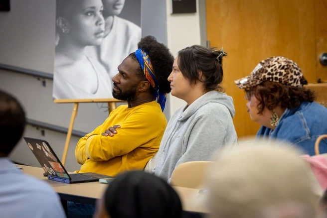 Three adult students in a classroom setting