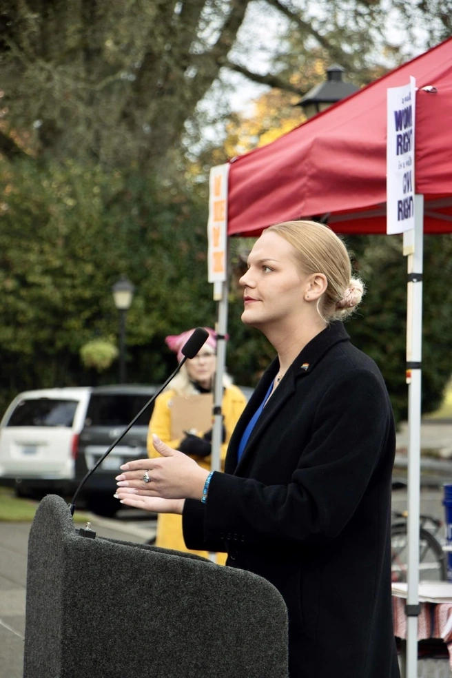 Jacie Hoag in profile speaking at a podium