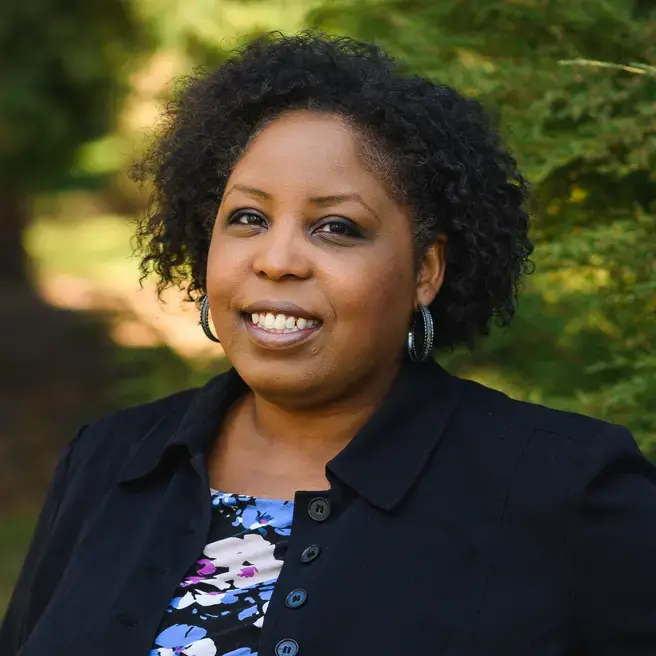 Portrait of Dionne Bonner a smiling woman with dark hair photographed outdoors