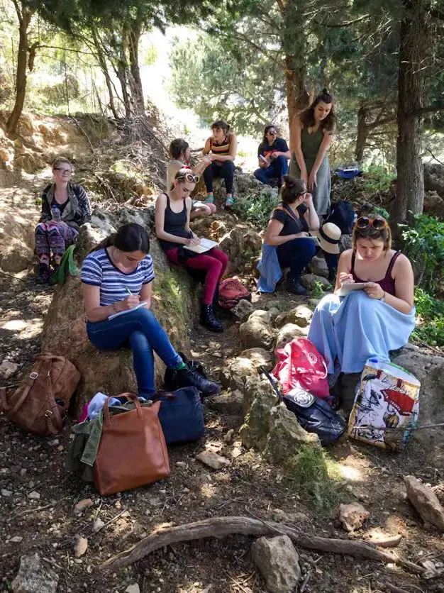 students sitting on a small hill covered in roots