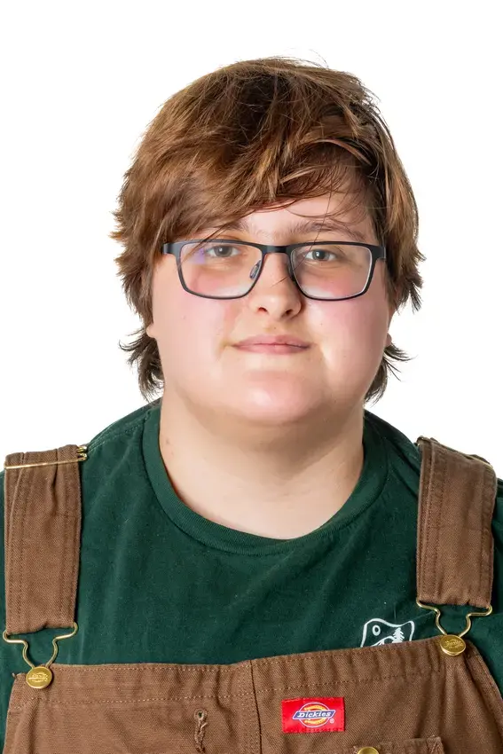photo of a person wearing glasses and overalls looking directly at the camera