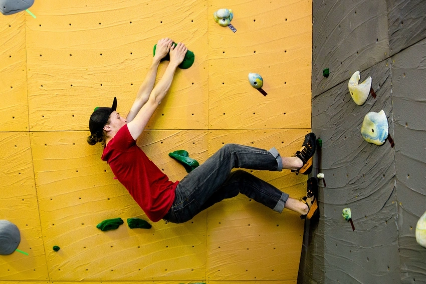 Student attempting a climbing gym route