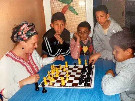 Christine Carlson in Morocco playing chess with children during her time with the Peace Corps